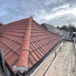 The roofing of a house is being re-tiled.