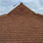 The roof of a house, with brown shingles, requires roof repair.