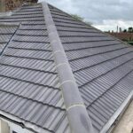 A grey tiled new roof on a house.