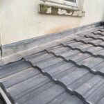 The roof of a house has been re-tiled by professional roofers.