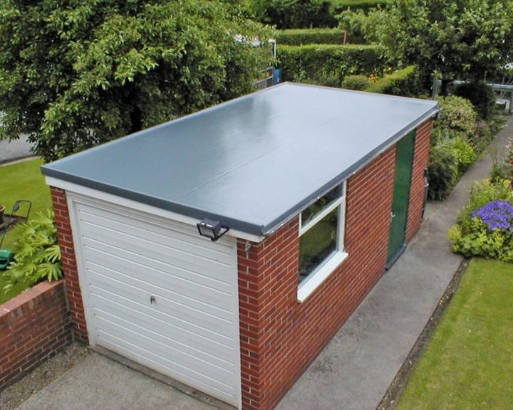 An aerial view of a garage with a flat roof showcases the roofer's skill in roofing.