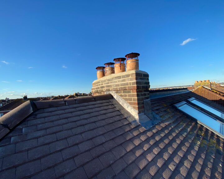 An aerial view of a roof with chimneys undergoing roof repair.