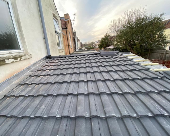 The roofing of a house is being re-tiled.