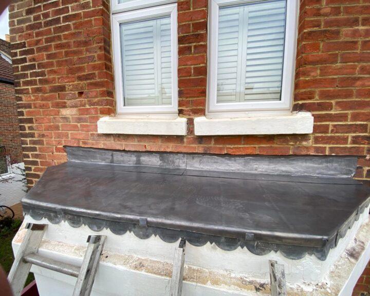 Roofers installing a flat roof on a house in London.