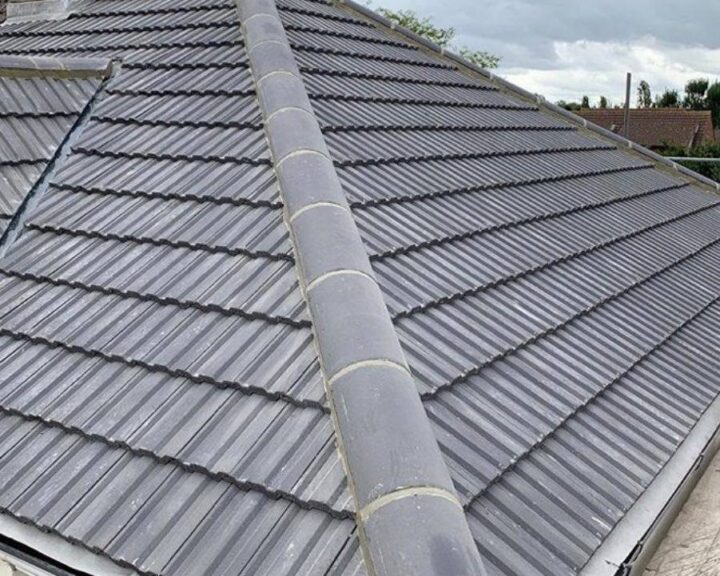 A grey tiled new roof on a house.