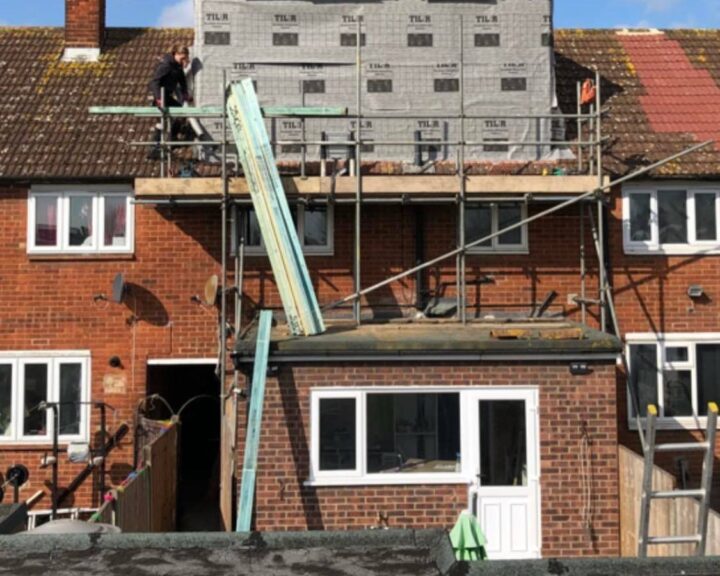 A man is working on a new roof of a house.